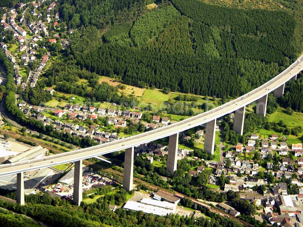 Aerial image Siegen - 27.08.2005 Siegen; Die Siegtalbrücke ist eine Autobahn-Brücke zwischen den Anschlussstellen 21 Siegen und 22 Siegen-Eisern der A 45. Sie überquert das Siegtal bei Eiserfeld, einem Stadtteil von Siegen. Gebaut wurde die Brücke von 1964 bis 1969 nach dem Entwurf von Hans Wittfoht. Mit einer Höhe von fast 96 Metern ist sie die höchste Brücke im Zuge der A 45 und eine der höchsten Autobahnbrücken in Deutschland. Sie besteht aus zwei getrennten, je 1.050 m langen Brückenkonstruktionen. Dabei ruht sie auf insgesamt 12 Pfeilern welche zwischen 63 und 105 m auseinan derliegen. Die auf diesen Pfeilern ruhenden, 5,80 m hohen Hohlkästen sind mit ihren seitlichen Auslegen insgesamt 30.50 m breit. Der Hauptradius der Brücke beträgt 1.400 m.