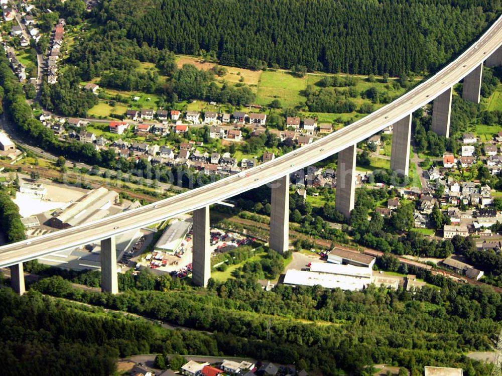 Siegen from the bird's eye view: 27.08.2005 Siegen; Die Siegtalbrücke ist eine Autobahn-Brücke zwischen den Anschlussstellen 21 Siegen und 22 Siegen-Eisern der A 45. Sie überquert das Siegtal bei Eiserfeld, einem Stadtteil von Siegen. Gebaut wurde die Brücke von 1964 bis 1969 nach dem Entwurf von Hans Wittfoht. Mit einer Höhe von fast 96 Metern ist sie die höchste Brücke im Zuge der A 45 und eine der höchsten Autobahnbrücken in Deutschland. Sie besteht aus zwei getrennten, je 1.050 m langen Brückenkonstruktionen. Dabei ruht sie auf insgesamt 12 Pfeilern welche zwischen 63 und 105 m auseinan derliegen. Die auf diesen Pfeilern ruhenden, 5,80 m hohen Hohlkästen sind mit ihren seitlichen Auslegen insgesamt 30.50 m breit. Der Hauptradius der Brücke beträgt 1.400 m.