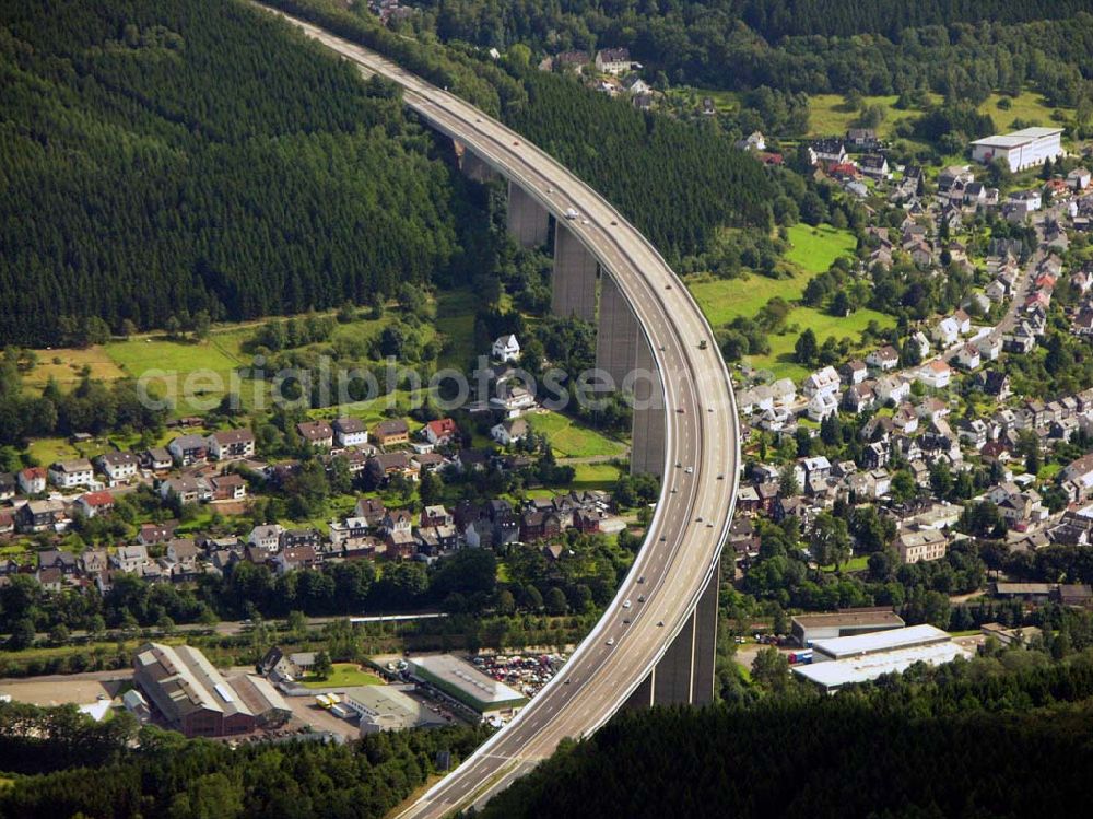 Aerial image Siegen - 27.08.2005 Siegen; Die Siegtalbrücke ist eine Autobahn-Brücke zwischen den Anschlussstellen 21 Siegen und 22 Siegen-Eisern der A 45. Sie überquert das Siegtal bei Eiserfeld, einem Stadtteil von Siegen. Gebaut wurde die Brücke von 1964 bis 1969 nach dem Entwurf von Hans Wittfoht. Mit einer Höhe von fast 96 Metern ist sie die höchste Brücke im Zuge der A 45 und eine der höchsten Autobahnbrücken in Deutschland. Sie besteht aus zwei getrennten, je 1.050 m langen Brückenkonstruktionen. Dabei ruht sie auf insgesamt 12 Pfeilern welche zwischen 63 und 105 m auseinan derliegen. Die auf diesen Pfeilern ruhenden, 5,80 m hohen Hohlkästen sind mit ihren seitlichen Auslegen insgesamt 30.50 m breit. Der Hauptradius der Brücke beträgt 1.400 m.