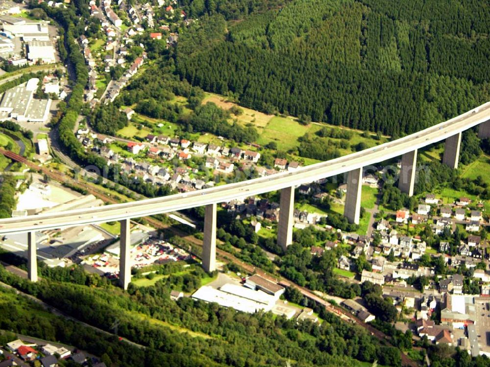 Aerial photograph Siegen - 27.08.2005 Siegen; Die Siegtalbrücke ist eine Autobahn-Brücke zwischen den Anschlussstellen 21 Siegen und 22 Siegen-Eisern der A 45. Sie überquert das Siegtal bei Eiserfeld, einem Stadtteil von Siegen. Gebaut wurde die Brücke von 1964 bis 1969 nach dem Entwurf von Hans Wittfoht. Mit einer Höhe von fast 96 Metern ist sie die höchste Brücke im Zuge der A 45 und eine der höchsten Autobahnbrücken in Deutschland. Sie besteht aus zwei getrennten, je 1.050 m langen Brückenkonstruktionen. Dabei ruht sie auf insgesamt 12 Pfeilern welche zwischen 63 und 105 m auseinan derliegen. Die auf diesen Pfeilern ruhenden, 5,80 m hohen Hohlkästen sind mit ihren seitlichen Auslegen insgesamt 30.50 m breit. Der Hauptradius der Brücke beträgt 1.400 m.