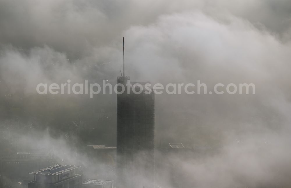 Essen from the bird's eye view: View of the top of the RWE tower breaking through an impressive blanket of fog and clouds over the city center of Essen in the state North Rhine-Westphalia. The autumn weather clouds are surrounding the skyscraper headquarters of energy supplier RWE at Opernplatz and form a cloud bank over the Ruhr region city