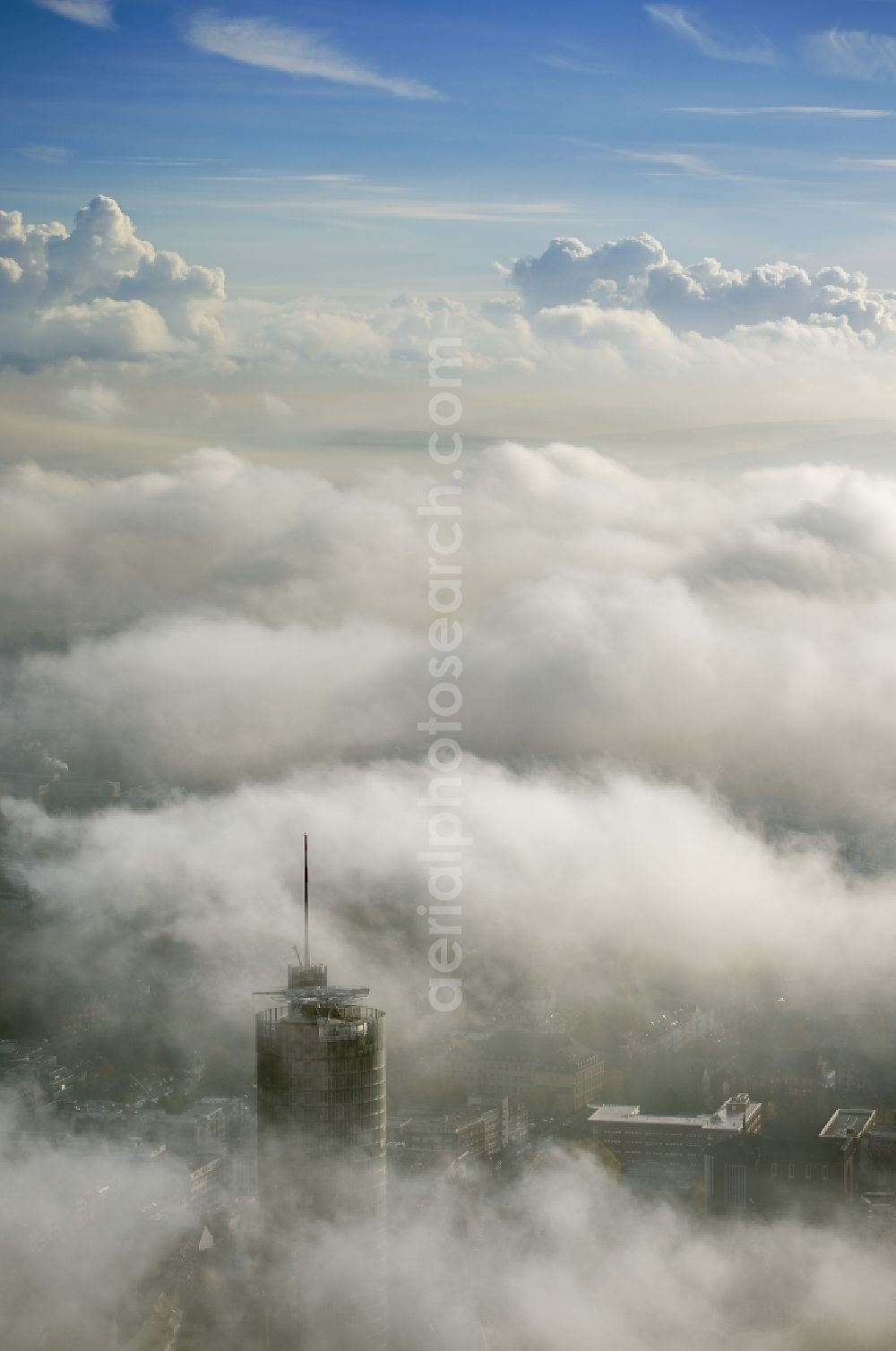 Aerial image Essen - View of the top of the RWE tower breaking through an impressive blanket of fog and clouds over the city center of Essen in the state North Rhine-Westphalia. The autumn weather clouds are surrounding the skyscraper headquarters of energy supplier RWE at Opernplatz and form a cloud bank over the Ruhr region city