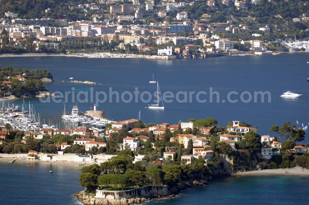 Aerial image Saint-Jean-Cap-Ferrat - Blick auf die Spitze Saint Hospice der Halbinsel Saint-Jean-Cap-Ferrat und die Hafeneinfahrt. Das Cap Ferrat ist eine Halbinsel an der Cote d'Azur. Sie liegt zwischen Nizza und Monaco. Es trennt Beaulieu-sur-Mer und Villefranche-sur-Mer. Der Ort Saint-Jean-Cap-Ferrat erstreckt sich an seinem Ostufer. Die ganze Halbinsel kann auf einem Fußweg umrundet werden. An ihrer Spitze steht ein Leuchtturm als Hafenwegweiser.