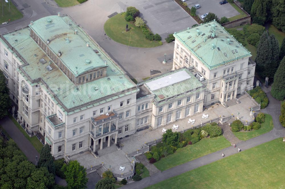 Aerial photograph ESSEN - Die Villa Hügel, im Essener Stadtteil Bredeney gelegen, wurde 1873 von Alfred Krupp errichtet und ist das ehemalige Wohn- und Repräsentationshaus der Industriellenfamilie Krupp. Die Villa hat 269 Räume, 8100 m² Wohn- und Nutzfläche und liegt in einem 28 Hektar großen Park an prominenter Stelle über dem Ruhrtal und dem Baldeneysee. Verwaltet wird sie heute durch die Kulturstiftung Ruhr, welche regelmäßig Veranstaltungen wie Konzerte oder Ausstellungen dort durchführt. Außerhalb dieser Zeiten kann sie in den Öffnungszeiten besichtigt werden.Die Entstehung der Villa Hügel geht einher mit den Veränderungen in der Friedrich Krupp AG. 1862 wurde durch Alfred Krupp die Prokura eingeführt. Er beabsichtigte damit seine Rolle in der stark gewachsenen Firma auf die strategischen Entscheidungen und die Aufsichtsfunktion zu beschränken. War es bis dato üblich, auf dem Firmengelände zu leben, spiegelt sich dieser „Rückzug“ auch in der Verlagerung des Wohnsitzes der Familie wieder. Im Herbst 1863 besichtigte Krupp das heutige Gelände der Villa und entschloss sich im Januar 1864 soviel wie möglich des damaligen Gutes Klosterbuschhof zu erwerben. Um den Umzug zu beschleunigen, wurde zunächst der Klosterbuschhof um einen Turm erweitert und zu einer Villa umgebaut. Erste Skizzen des Baues wurden von Krupp selbst entworfen und dem firmeninternen Baubüro, zunächst unter der Leitung von Ferdinand Barchewitz, ab 1863 unter der Leitung von Gustav Kraemer, zur weiteren Bearbeitung vorgelegt. Barchewitz fertigte, nachdem Kraemer die Leitung des Baubüros übernommen hatte, Pläne nach den Skizzen Krupps an, welche als Grundlage für die weiteren Planungen dienten. Über den ganzen Zeitraum hinweg unterstützte auch der aus Heinersdorf stammende Architekt Thomas Obstfelder die Arbeiten.1953 stellte die Familie Krupp ihren Wohnsitz für eine bedeutende Kunstausstellung zur Verfügung, die nicht die letzte bleiben sollte. Bis Ende der 90er fungierte die Villa Hügel auch als Repräsentationsgebäude der Firma ThyssenKrupp. 1984 rief man die Kulturstiftung Ruhr ins Leben, die regelmäßig Ausstellungen in der Villa Hügel organisiert. Im Nebengebäude ist das Krupp-Museum zur Firmengeschichte untergebracht.