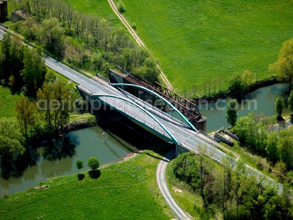 Gerstungen from the bird's eye view: The Werra bridge in Gerstungen in the state of Thuringia. The bridge with its distinct blueish arcs leads over the river Werra from the East into the town of Gerstungen. Next to it are remains of an old railway bridge. The bridge holds the country road L1020