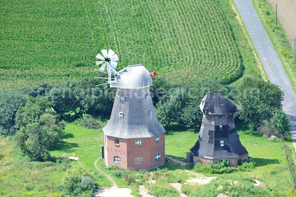 Aerial photograph Neu Vorwerk - Blick auf die Zwillingsmühlen von Neu Vorwerk in Mecklenburg-Vorpommern. Bei diesem einzigartigen technischen Denkmal auf dem Mühlenberg zwischen Neu Vorwerk und Alt Vorwerk präsentieren sich dem Besucher zwei Windmühlen als Wahrzeichen nebeneinan der. 1847 kam es zur Errichtung des Erdholländers auf dem Gut Alt Vorwerk. 1949 kam es zum Neubau des großes Galerieholländers. Er stellt wohl den letzten Windmühlenneubau Deutschlands dar. Twin Mills of New Vorwerk.