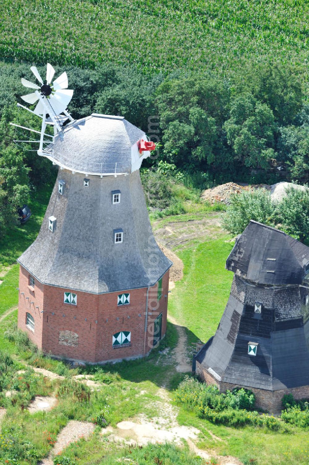 Neu Vorwerk from the bird's eye view: Blick auf die Zwillingsmühlen von Neu Vorwerk in Mecklenburg-Vorpommern. Bei diesem einzigartigen technischen Denkmal auf dem Mühlenberg zwischen Neu Vorwerk und Alt Vorwerk präsentieren sich dem Besucher zwei Windmühlen als Wahrzeichen nebeneinan der. 1847 kam es zur Errichtung des Erdholländers auf dem Gut Alt Vorwerk. 1949 kam es zum Neubau des großes Galerieholländers. Er stellt wohl den letzten Windmühlenneubau Deutschlands dar. Twin Mills of New Vorwerk.