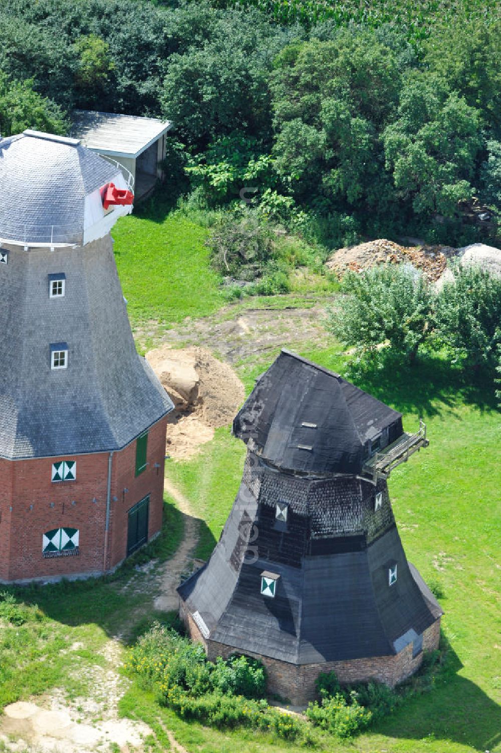 Aerial image Neu Vorwerk - Blick auf die Zwillingsmühlen von Neu Vorwerk in Mecklenburg-Vorpommern. Bei diesem einzigartigen technischen Denkmal auf dem Mühlenberg zwischen Neu Vorwerk und Alt Vorwerk präsentieren sich dem Besucher zwei Windmühlen als Wahrzeichen nebeneinan der. 1847 kam es zur Errichtung des Erdholländers auf dem Gut Alt Vorwerk. 1949 kam es zum Neubau des großes Galerieholländers. Er stellt wohl den letzten Windmühlenneubau Deutschlands dar. Twin Mills of New Vorwerk.