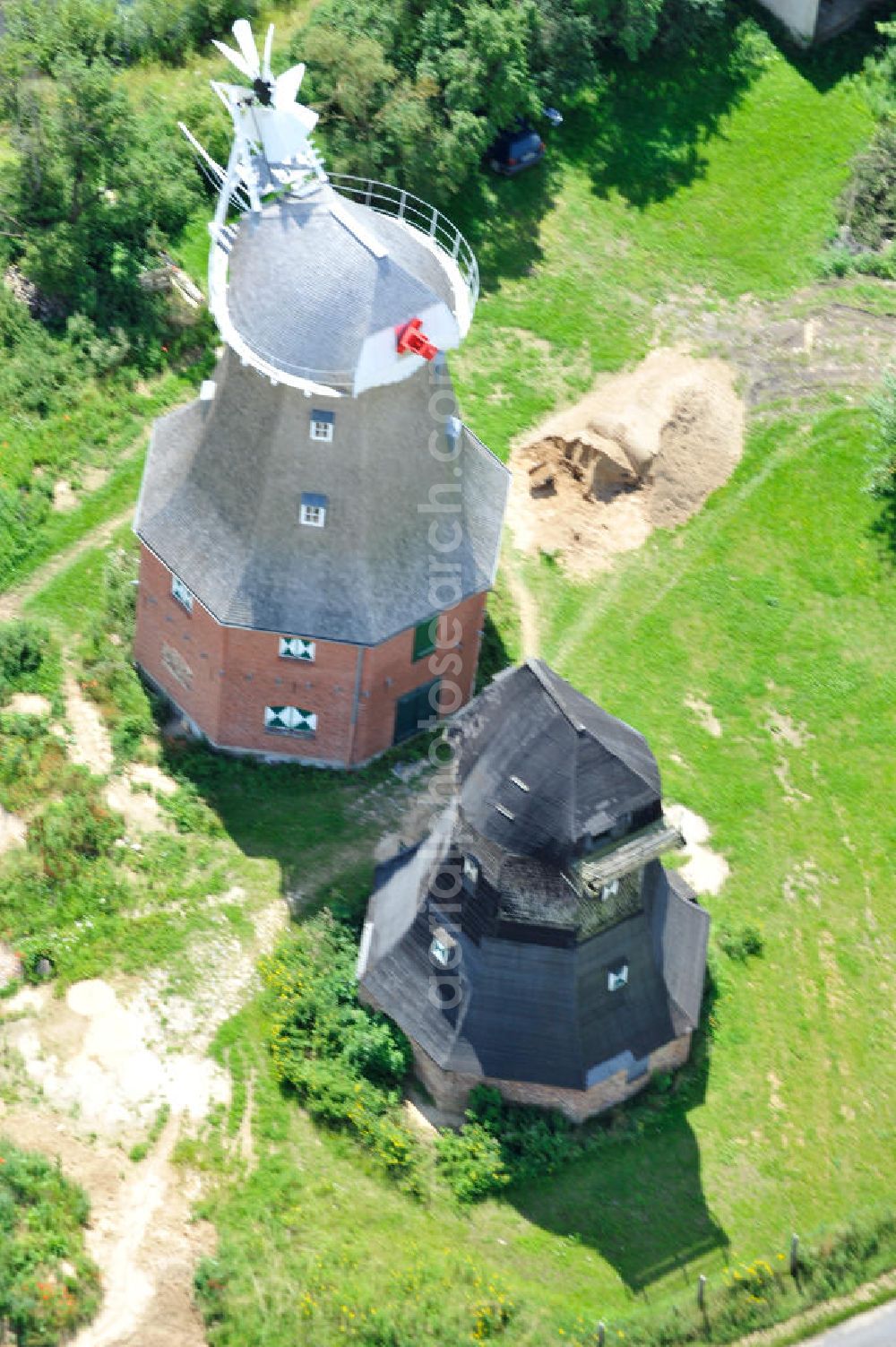 Neu Vorwerk from the bird's eye view: Blick auf die Zwillingsmühlen von Neu Vorwerk in Mecklenburg-Vorpommern. Bei diesem einzigartigen technischen Denkmal auf dem Mühlenberg zwischen Neu Vorwerk und Alt Vorwerk präsentieren sich dem Besucher zwei Windmühlen als Wahrzeichen nebeneinan der. 1847 kam es zur Errichtung des Erdholländers auf dem Gut Alt Vorwerk. 1949 kam es zum Neubau des großes Galerieholländers. Er stellt wohl den letzten Windmühlenneubau Deutschlands dar. Twin Mills of New Vorwerk.