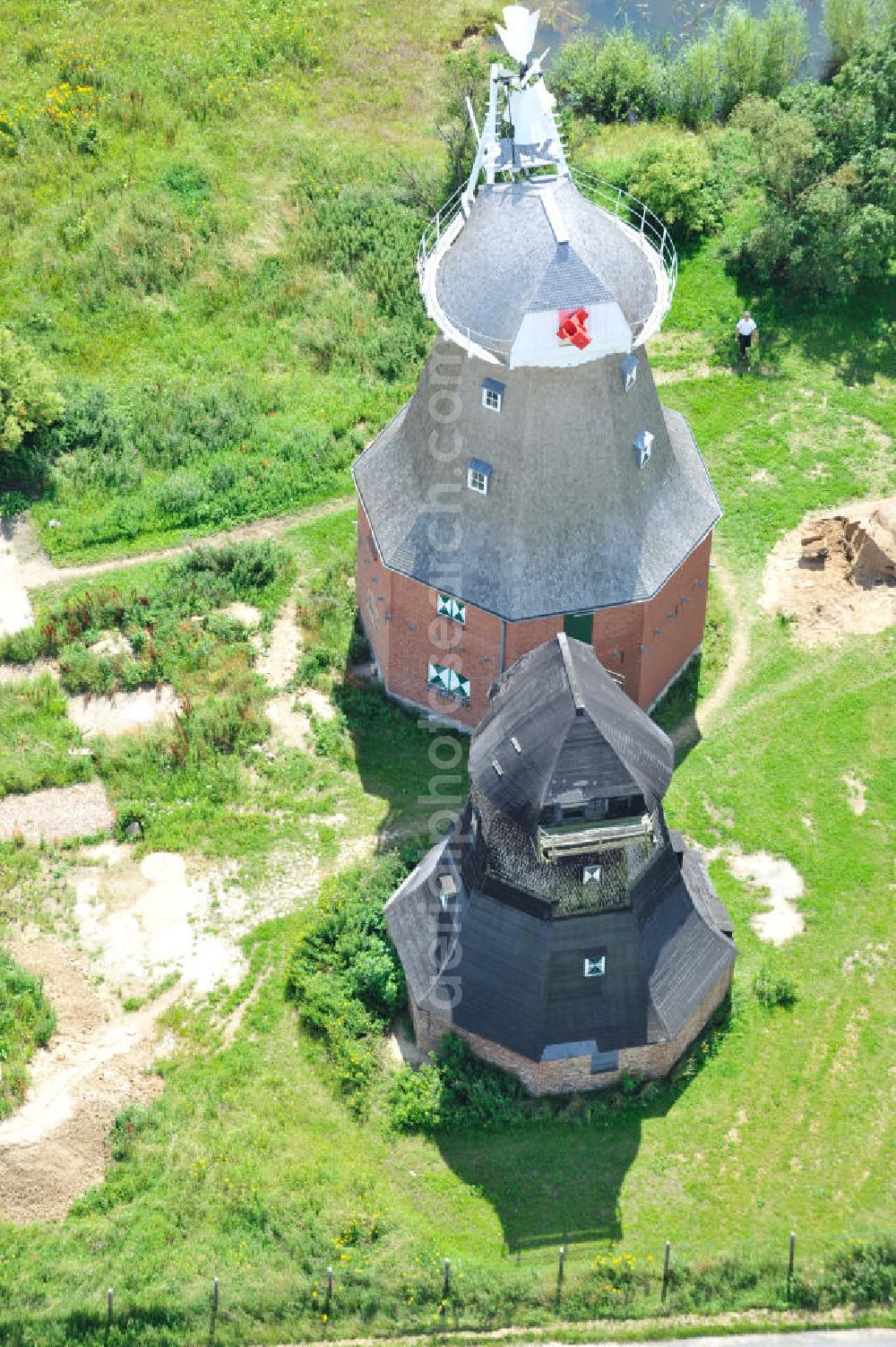 Aerial image Neu Vorwerk - Blick auf die Zwillingsmühlen von Neu Vorwerk in Mecklenburg-Vorpommern. Bei diesem einzigartigen technischen Denkmal auf dem Mühlenberg zwischen Neu Vorwerk und Alt Vorwerk präsentieren sich dem Besucher zwei Windmühlen als Wahrzeichen nebeneinan der. 1847 kam es zur Errichtung des Erdholländers auf dem Gut Alt Vorwerk. 1949 kam es zum Neubau des großes Galerieholländers. Er stellt wohl den letzten Windmühlenneubau Deutschlands dar. Twin Mills of New Vorwerk.