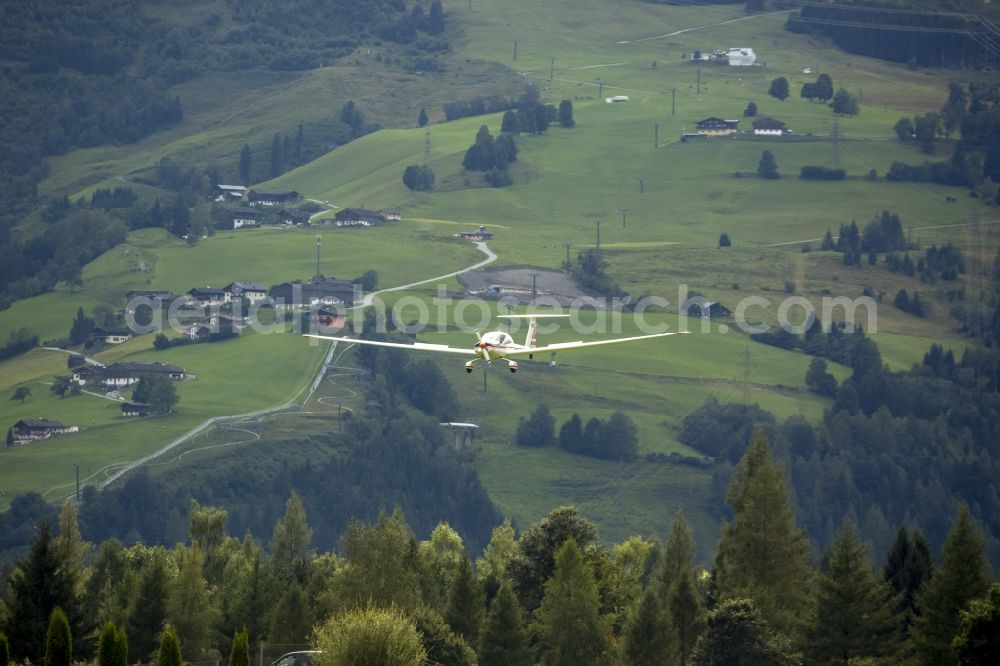 Zell am See from the bird's eye view: A motor glider of the class Diamond HK36 on a mountainside approaching Zell am See in the state Salzburg in Austria