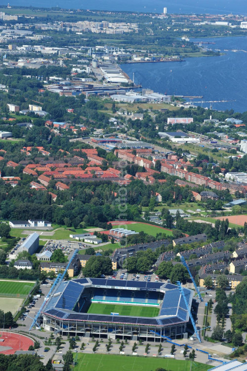 Rostock from the bird's eye view: Die DKB-Arena (von 1954 bis 2007 Ostseestadion) ist ein Fußballstadion in der Hansestadt Rostock, das als Veranstaltungsort insbesondere für Heimspiele des F.C. Hansa Rostock genutzt wird. Die Ostseestadion GmbH & Co. KG mit dem F.C. Hansa Rostock als einzigem Kommanditisten ist Betreiber der DKB-Arena. Im Dezember 2010 wurde auf dem Dach der DKB-Arena eine Solaranlage fertiggestellt, deren Betreiber Paribus northenergy mit dieser rund 600.000 kWh Strom jährlich produzieren will. The DKB-Arena, the stadium is a football stadium in the Hanseatic city of Rostock, as the venue especially for home games of FC Hansa Rostock is used.