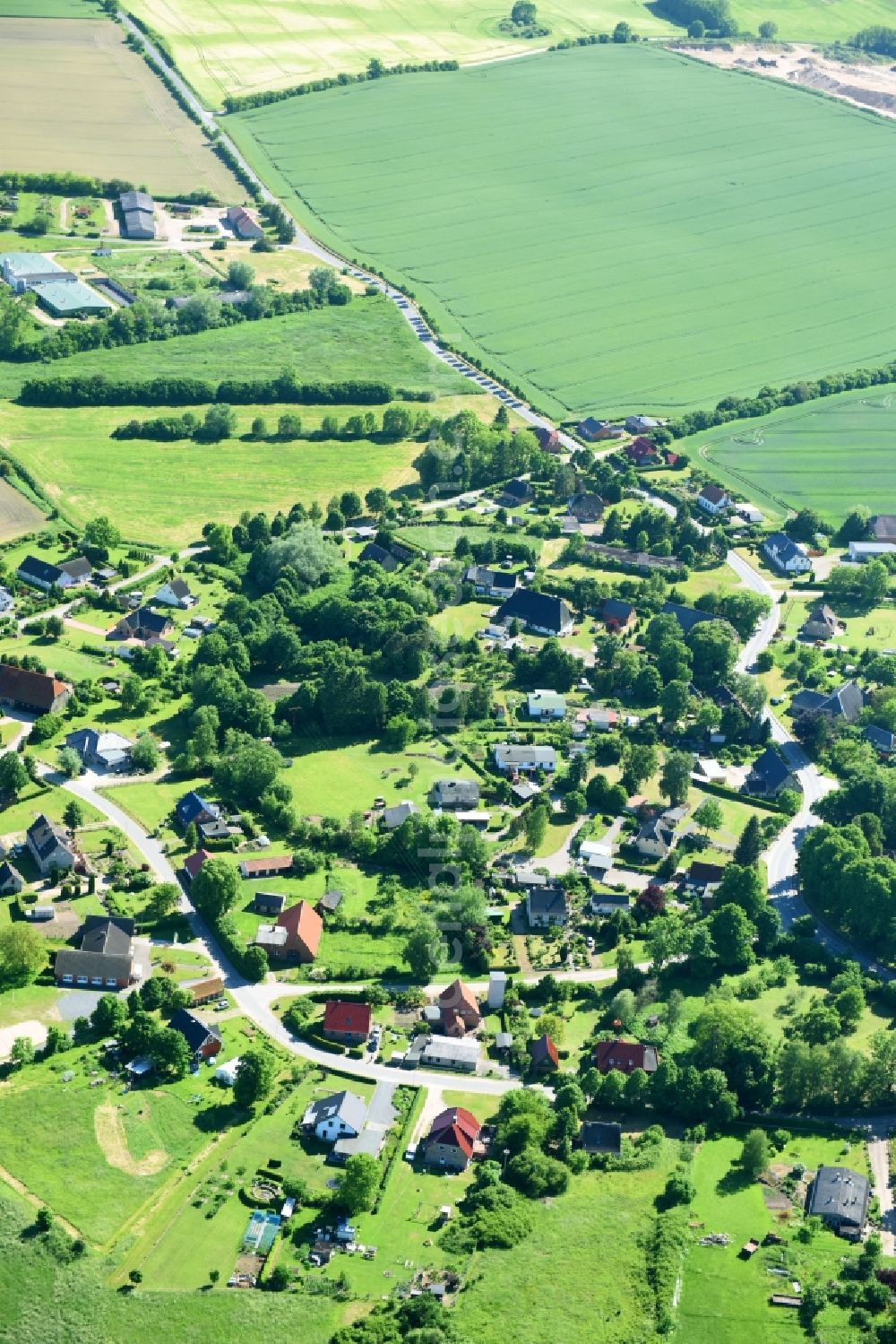 Roggenstorf from the bird's eye view: Village - view on the edge of agricultural fields and farmland in Roggenstorf in the state Mecklenburg - Western Pomerania, Germany