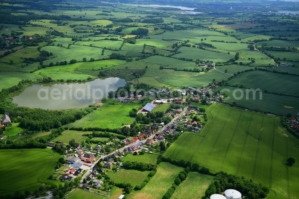 Bujendorf from above - Agricultural land and field borders surround the settlement area of the village in Bujendorf in the state Schleswig-Holstein, Germany