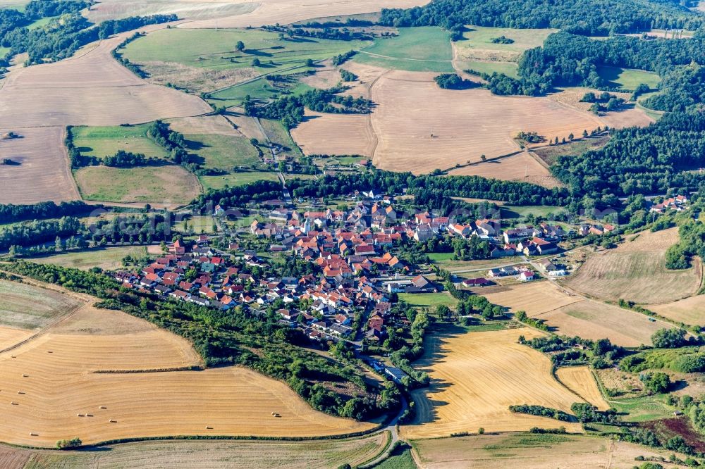 Niedermoschel from above - Agricultural land and field borders surround the settlement area of the village in Niedermoschel in the state Rhineland-Palatinate, Germany