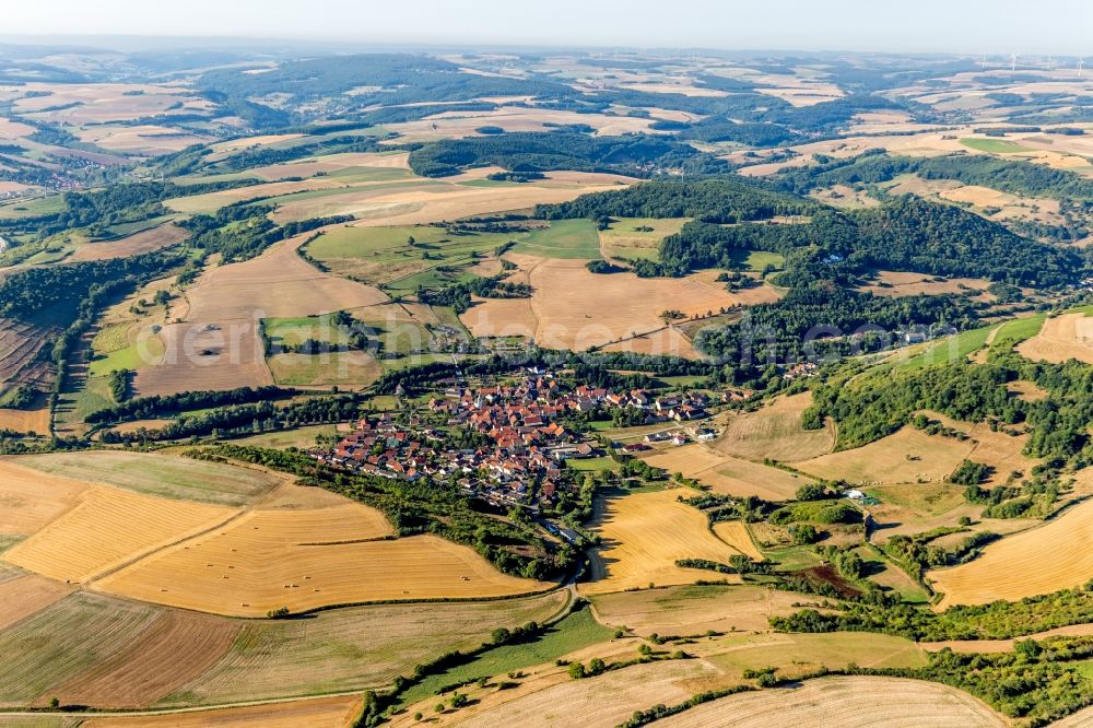 Niedermoschel from the bird's eye view: Agricultural land and field borders surround the settlement area of the village in Niedermoschel in the state Rhineland-Palatinate, Germany