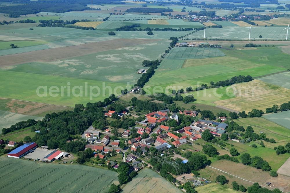 Sarnow from above - Agricultural land and field borders surround the settlement area of the village in Sarnow in the state Brandenburg, Germany