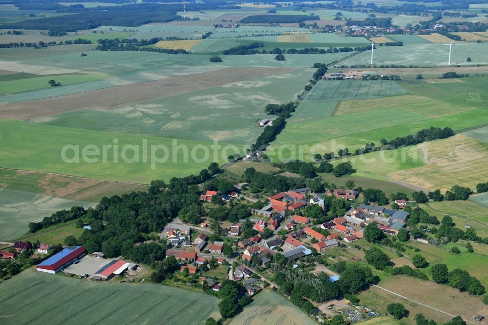 Sarnow from the bird's eye view: Agricultural land and field borders surround the settlement area of the village in Sarnow in the state Brandenburg, Germany