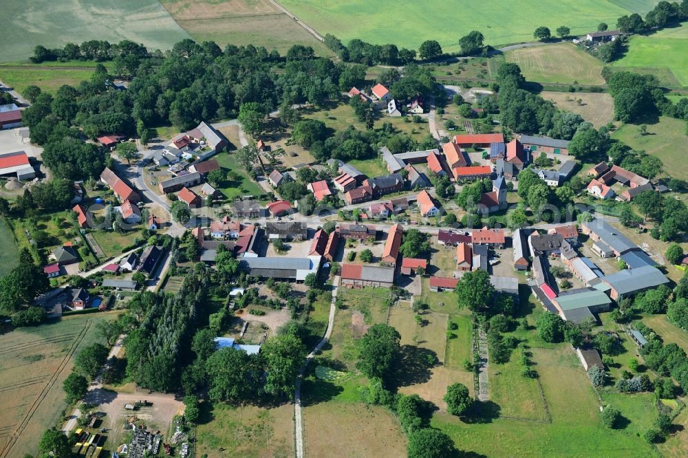 Aerial image Sarnow - Agricultural land and field borders surround the settlement area of the village in Sarnow in the state Brandenburg, Germany