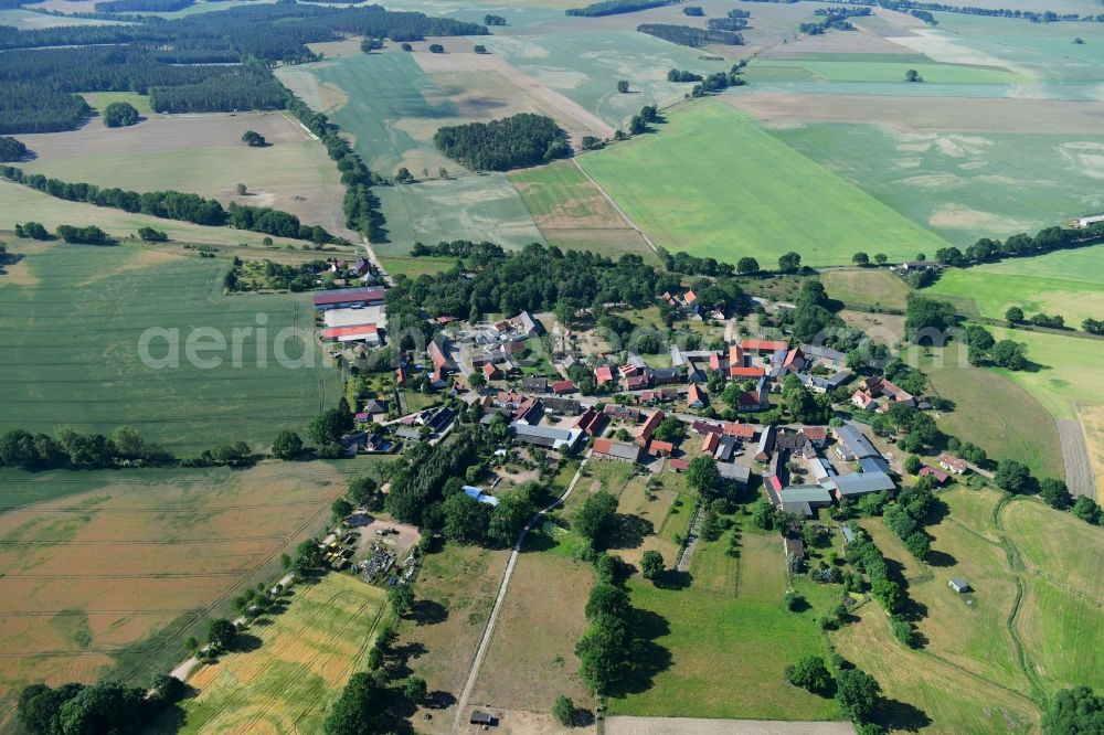 Sarnow from above - Agricultural land and field borders surround the settlement area of the village in Sarnow in the state Brandenburg, Germany