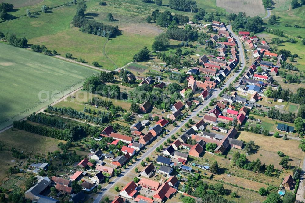 Wutike from the bird's eye view: Agricultural land and field borders surround the settlement area of the village in Wutike in the state Brandenburg, Germany