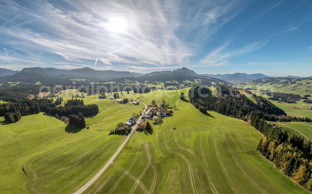 Oberellegg from above - Agricultural pastures surround the settlement area of the village in the district of Oberellegg in Wertach Allgaeu with the Gruenten summit in the background in the federal state of Bavaria, Germany