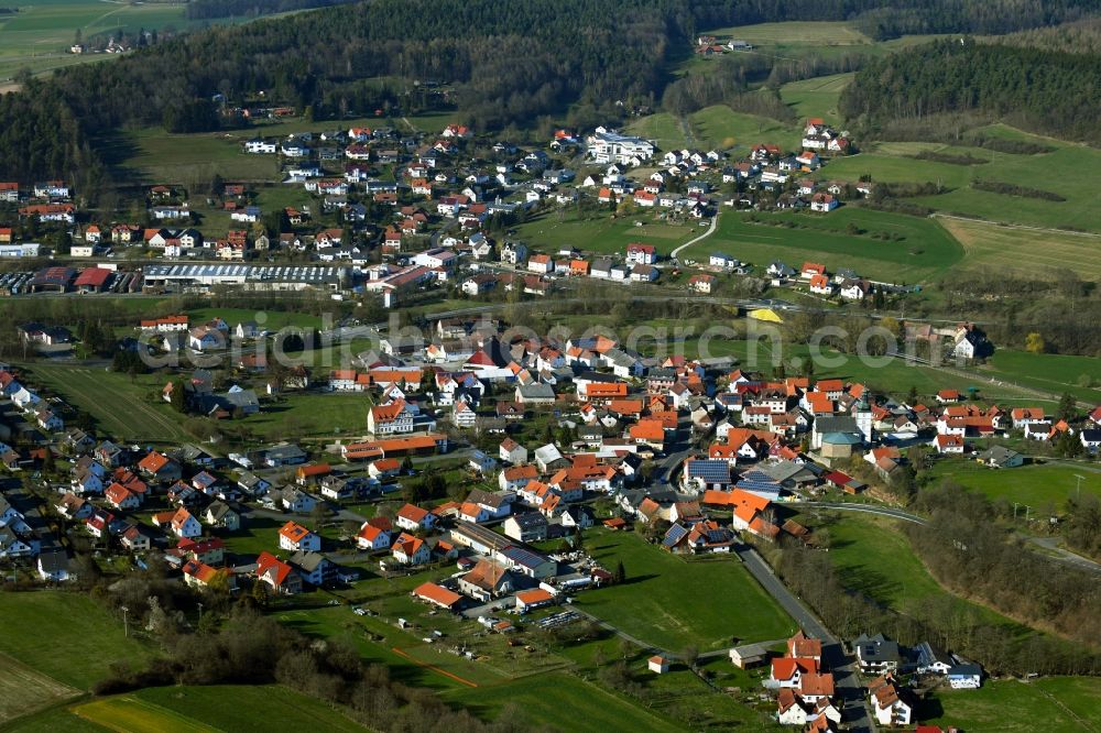 Thalau from the bird's eye view: Agricultural land and field borders surround the settlement area of the village in Thalau in the state Hesse, Germany