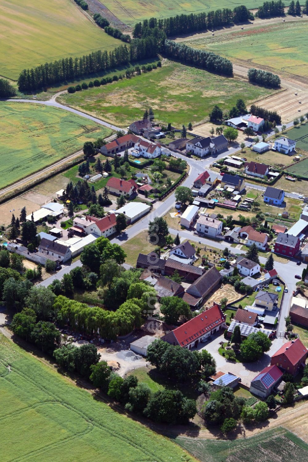 Krostitz from above - Agricultural land and field boundaries surround the settlement area of the village in Krostitz in the state Saxony, Germany