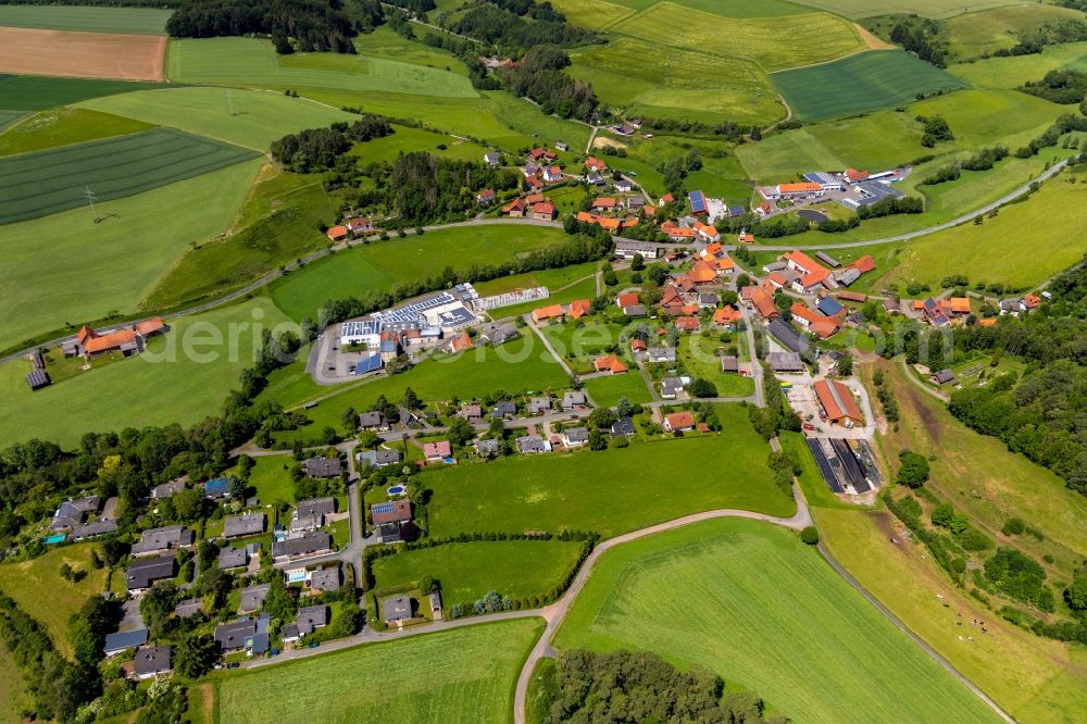 Alraft from above - Agricultural land and field borders surround the settlement area of the village in Alraft in the state Hesse, Germany