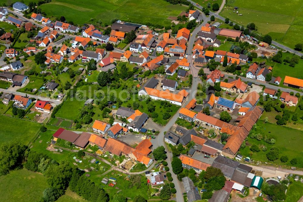 Aerial photograph Basdorf - Agricultural land and field borders surround the settlement area of the village in Basdorf in the state Hesse, Germany