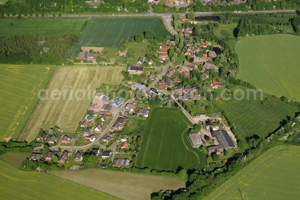 Aerial photograph Einhaus - Agricultural land and field borders surround the settlement area of the village in Einhaus in the state Schleswig-Holstein, Germany