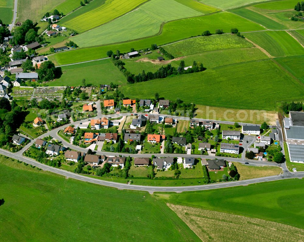 Ahornberg from the bird's eye view: Agricultural land and field boundaries surround the settlement area of the village in Ahornberg in the state Bavaria, Germany