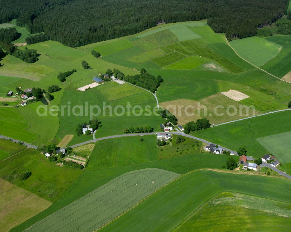 Ahornberg from the bird's eye view: Agricultural land and field boundaries surround the settlement area of the village in Ahornberg in the state Bavaria, Germany