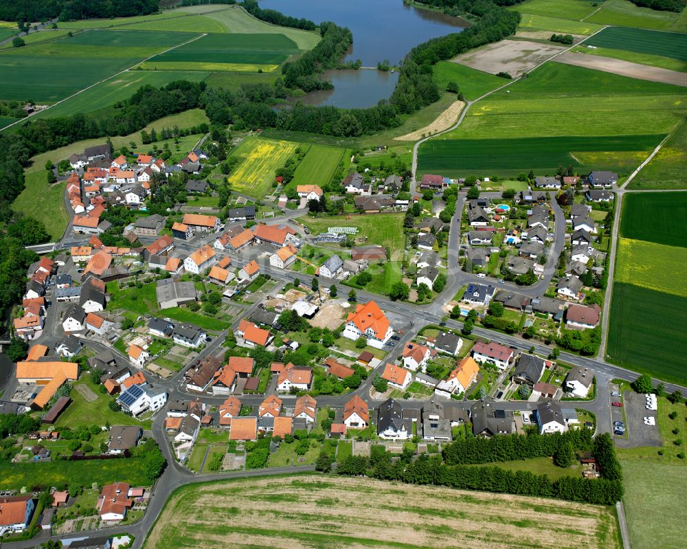 Angenrod from the bird's eye view: Agricultural land and field boundaries surround the settlement area of the village in Angenrod in the state Hesse, Germany