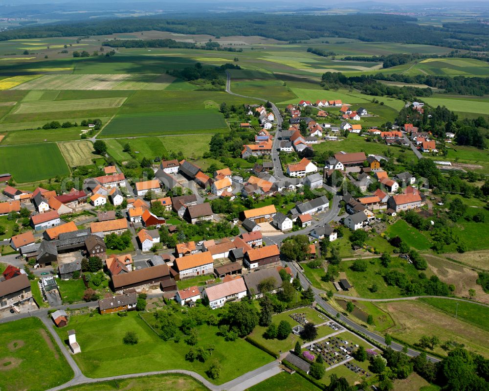 Arnshain from above - Agricultural land and field boundaries surround the settlement area of the village in Arnshain in the state Hesse, Germany