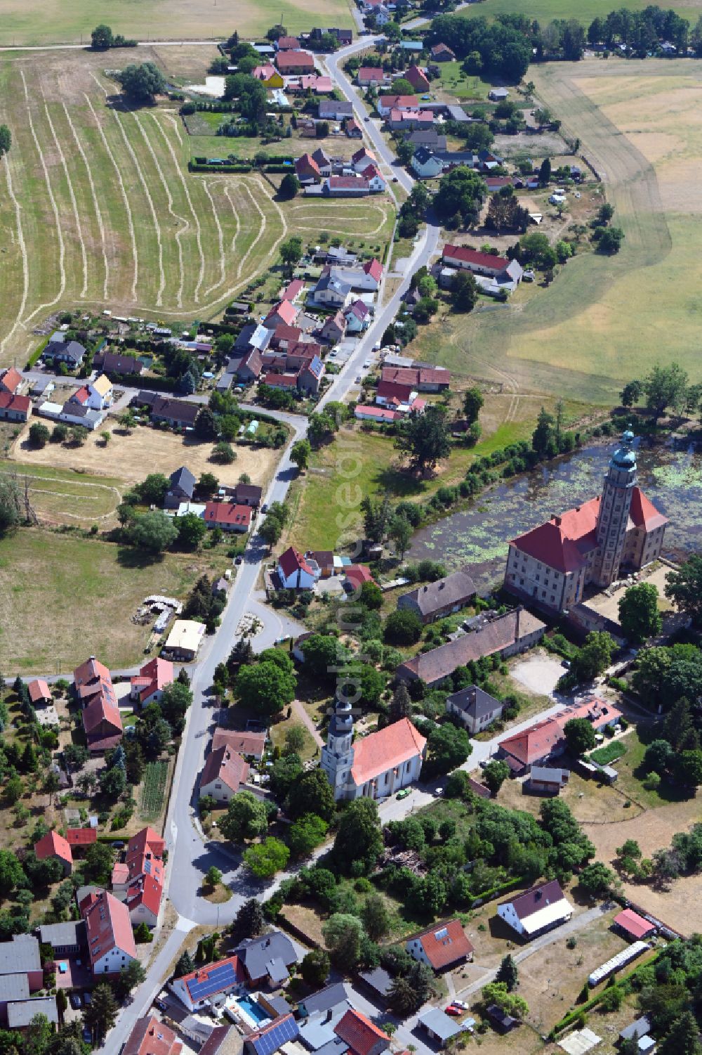 Bad Schmiedeberg from above - Agricultural land and field boundaries surround the settlement area of the village on street Dorfstrasse in the district Reinharz in Bad Schmiedeberg in the state Saxony-Anhalt, Germany