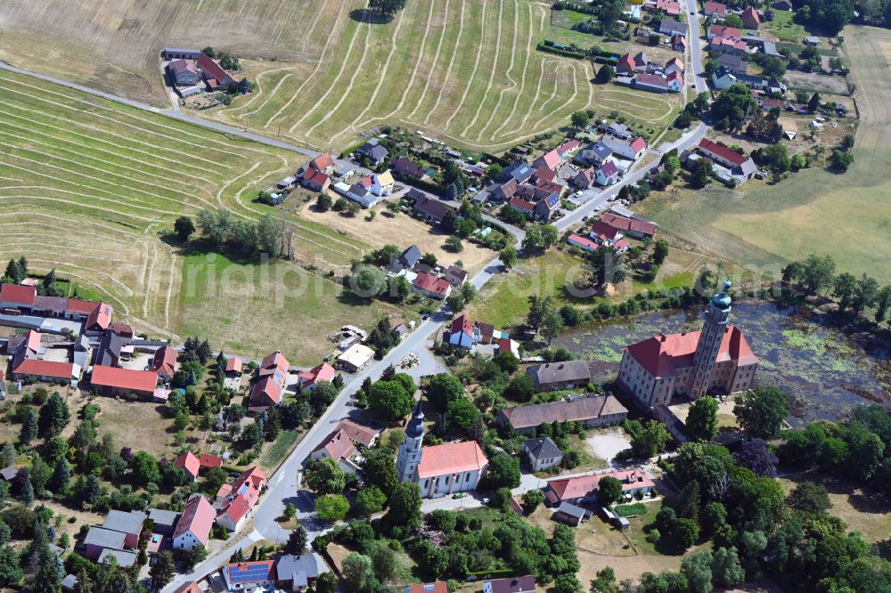 Bad Schmiedeberg from the bird's eye view: Agricultural land and field boundaries surround the settlement area of the village on street Dorfstrasse in the district Reinharz in Bad Schmiedeberg in the state Saxony-Anhalt, Germany