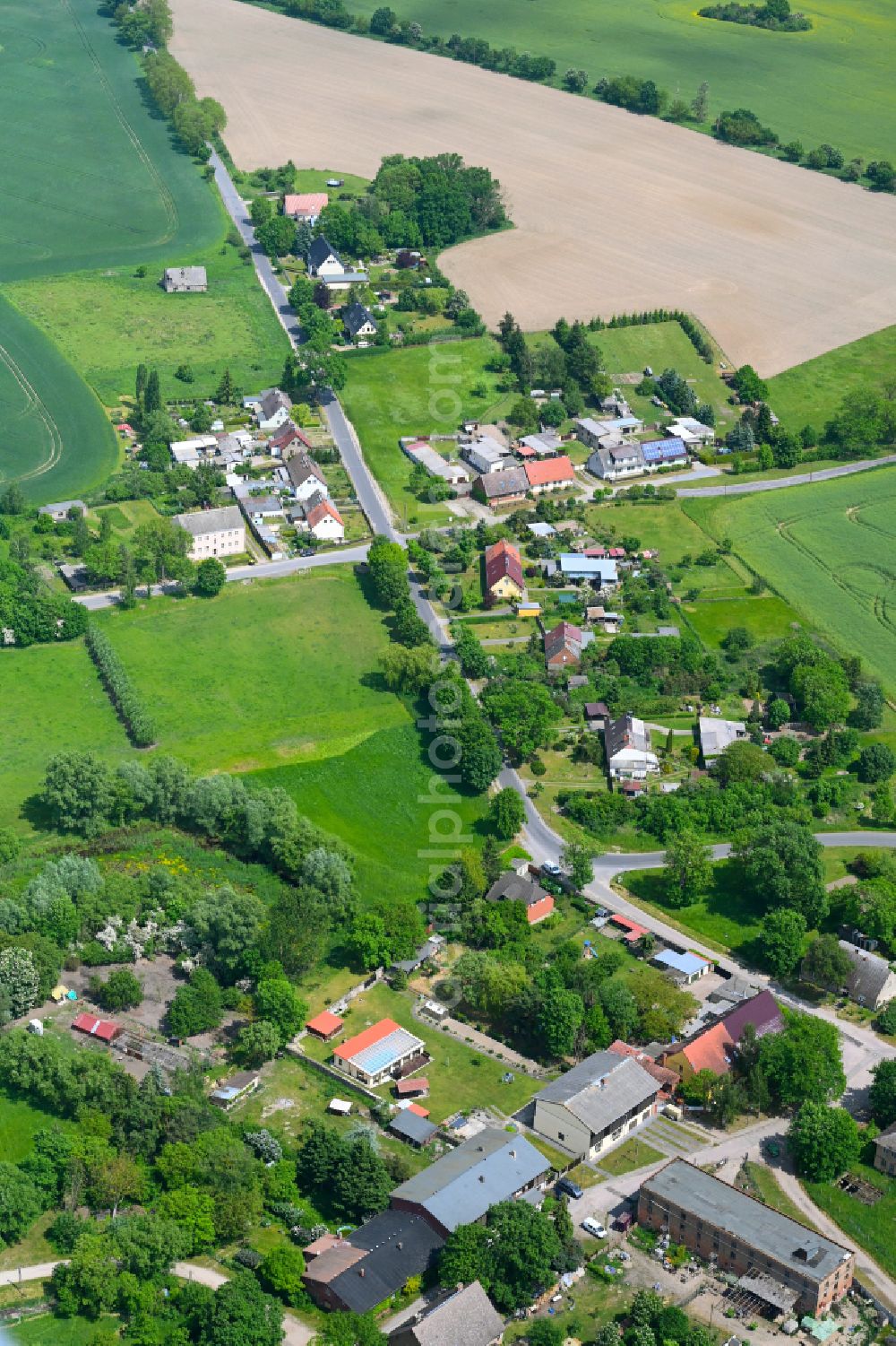 Aerial photograph Badingen - Agricultural land and field boundaries surround the settlement area of the village in Badingen in the state Brandenburg, Germany