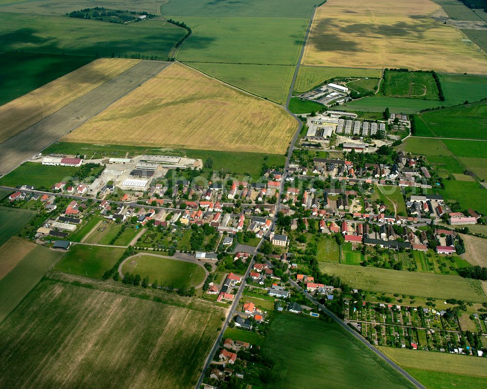 Bauda from above - Agricultural land and field boundaries surround the settlement area of the village in Bauda in the state Saxony, Germany