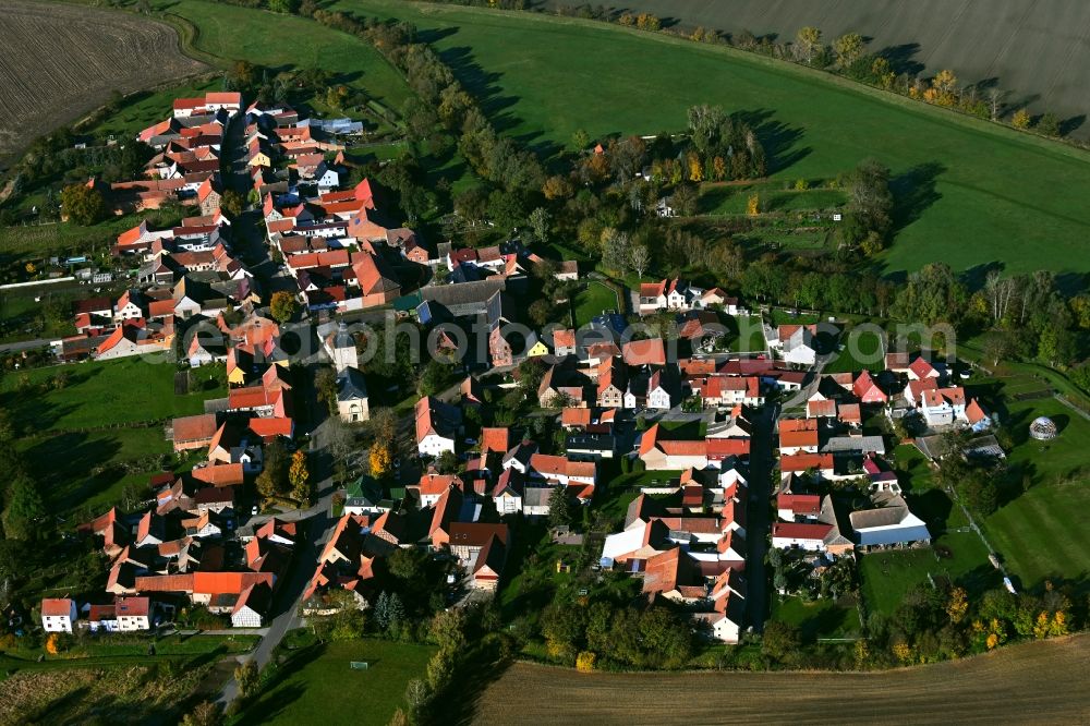 Büchel from above - Agricultural land and field boundaries surround the settlement area of the village in Buechel in the state Thuringia, Germany