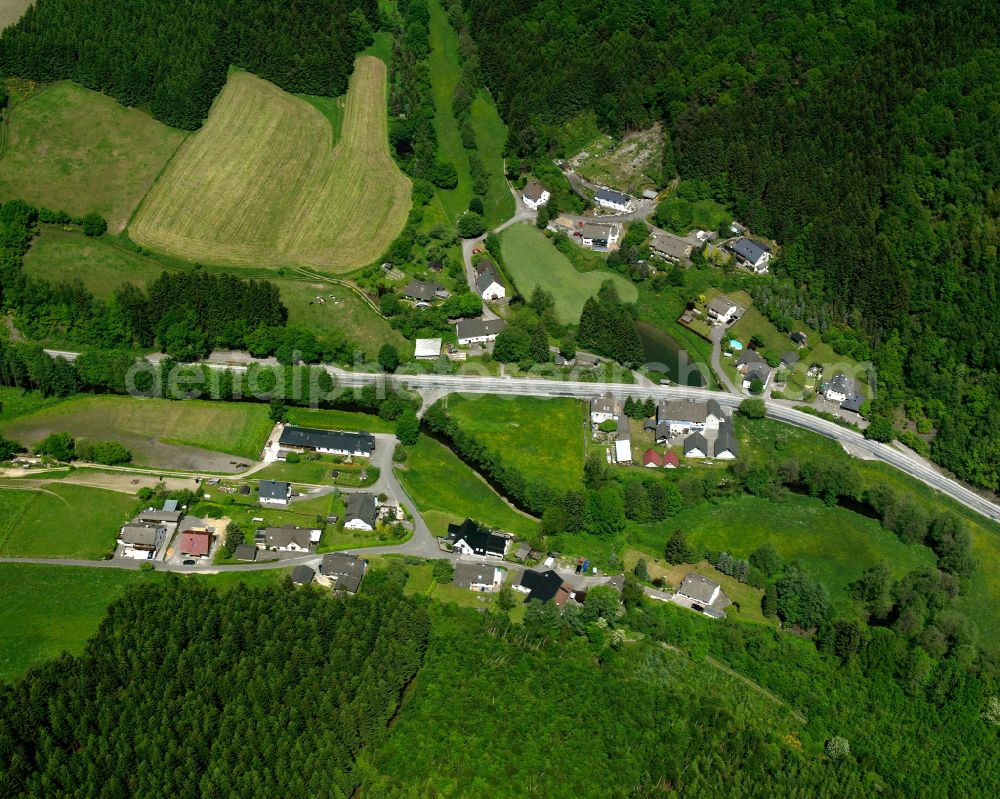 Berlinghausen from the bird's eye view: Agricultural land and field boundaries surround the settlement area of the village in Berlinghausen in the state North Rhine-Westphalia, Germany