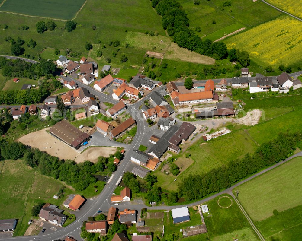 Bernsburg from the bird's eye view: Agricultural land and field boundaries surround the settlement area of the village in Bernsburg in the state Hesse, Germany