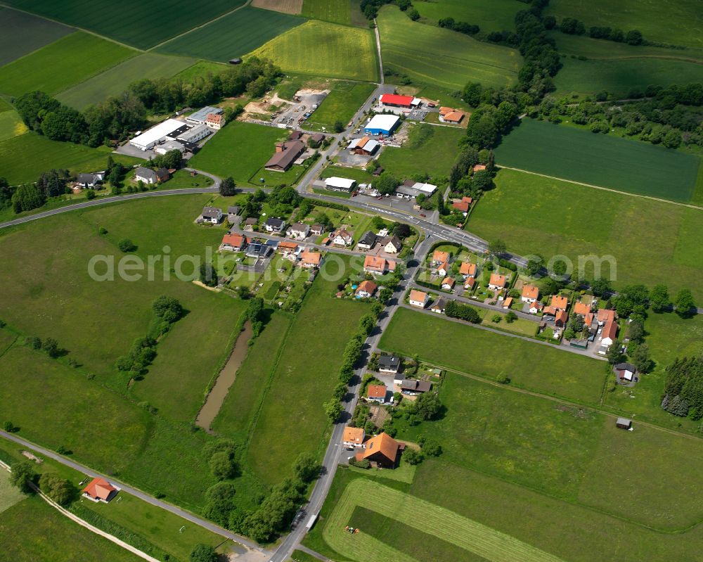 Bernshausen from above - Agricultural land and field boundaries surround the settlement area of the village in Bernshausen in the state Hesse, Germany