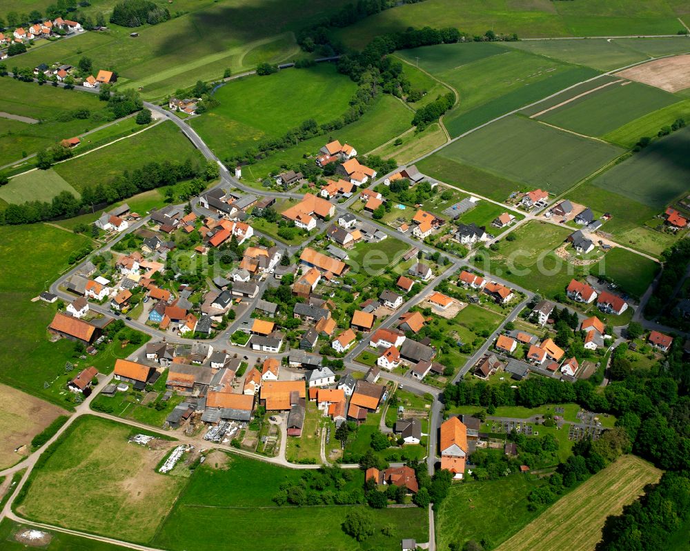 Bernshausen from the bird's eye view: Agricultural land and field boundaries surround the settlement area of the village in Bernshausen in the state Hesse, Germany