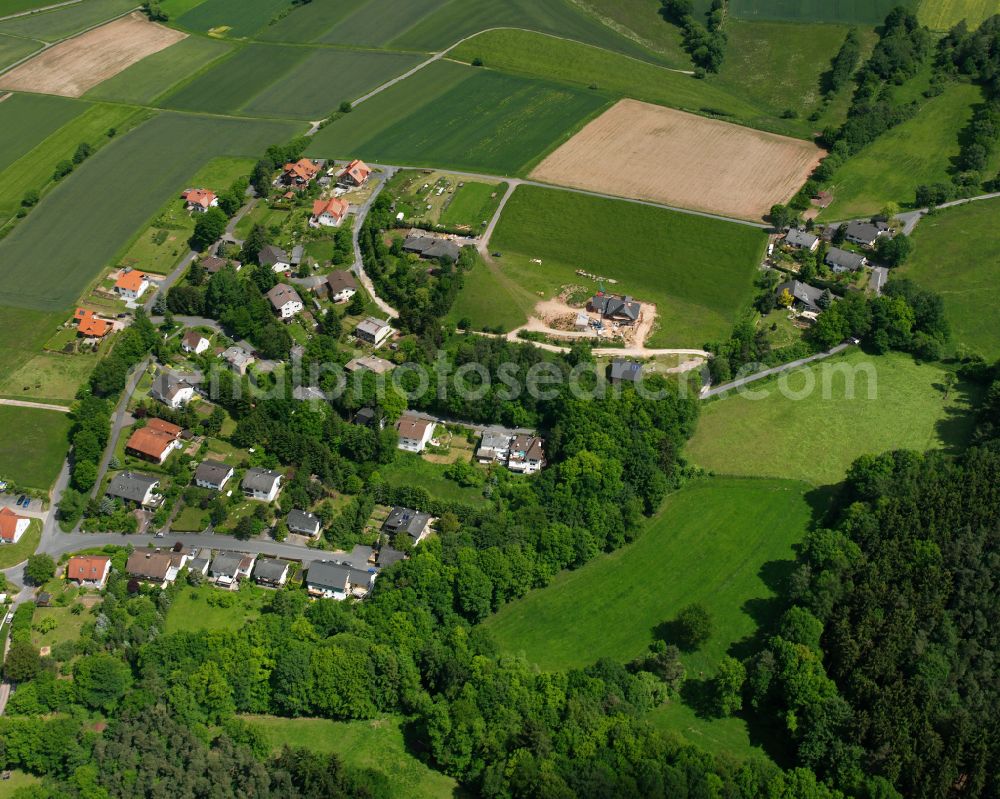 Aerial image Bernshausen - Agricultural land and field boundaries surround the settlement area of the village in Bernshausen in the state Hesse, Germany