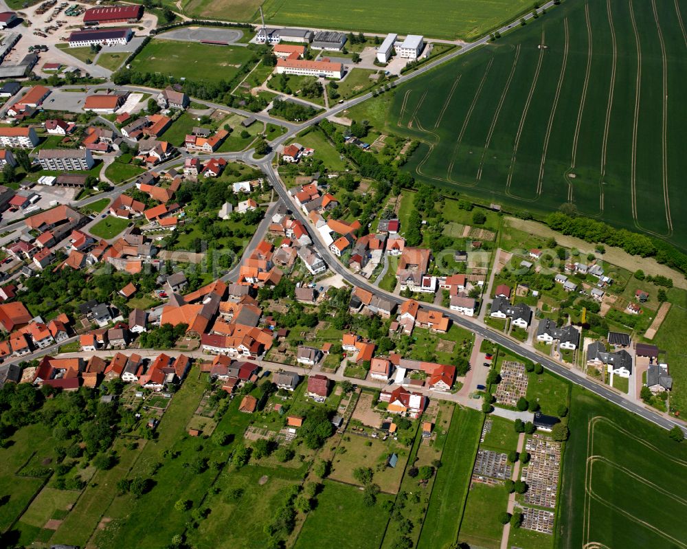 Aerial image Bischofferode - Agricultural land and field boundaries surround the settlement area of the village in Bischofferode in the state Thuringia, Germany