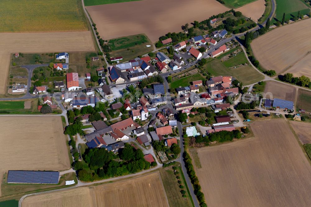 Bolzhausen from above - Agricultural land and field boundaries surround the settlement area of the village in Bolzhausen in the state Bavaria, Germany