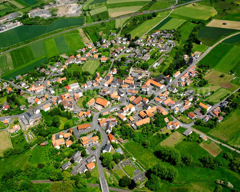 Brauerschwend from above - Agricultural land and field boundaries surround the settlement area of the village in Brauerschwend in the state Hesse, Germany