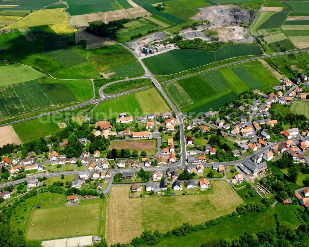 Brauerschwend from the bird's eye view: Agricultural land and field boundaries surround the settlement area of the village in Brauerschwend in the state Hesse, Germany