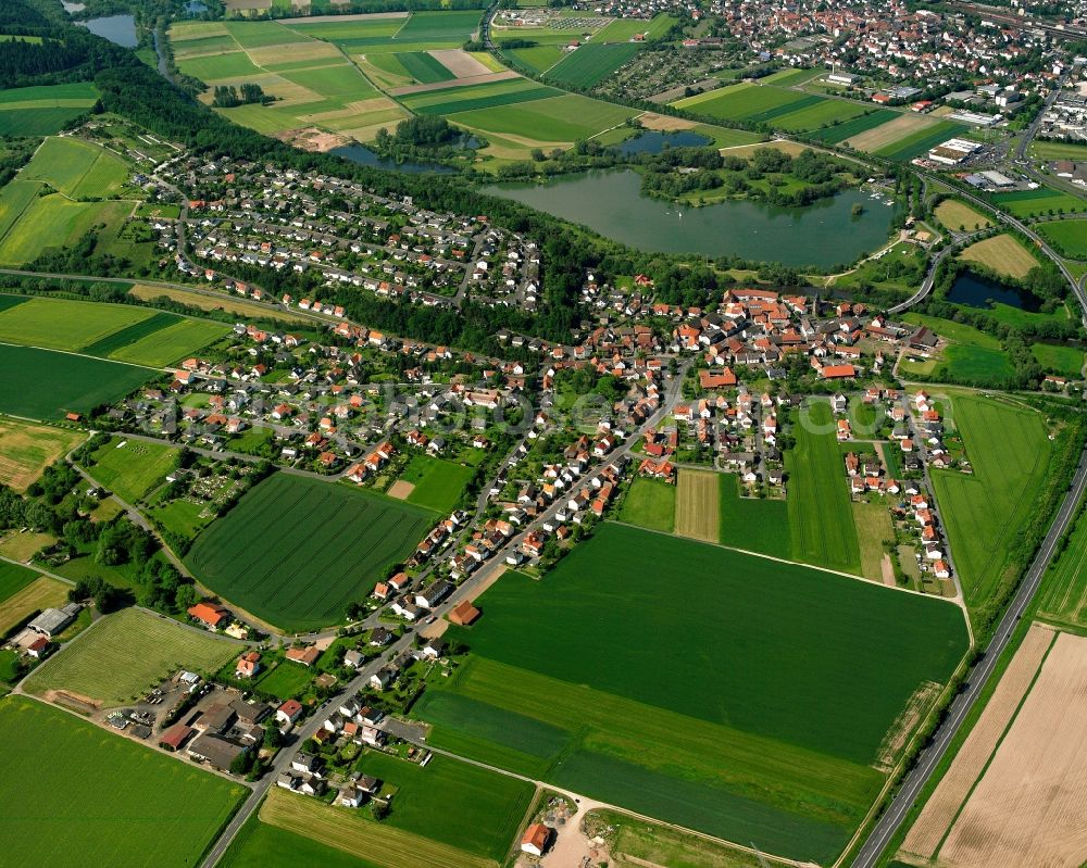 Aerial image Breitenbach - Agricultural land and field boundaries surround the settlement area of the village in Breitenbach in the state Hesse, Germany